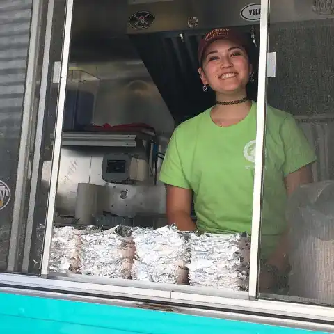 Team member smiling in the CrabTown Curbs truck's window.